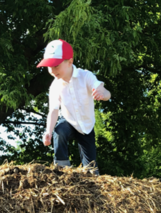 Junge auf Heuhaufen