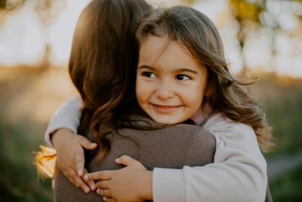 Kleines Mädchen auf Arm von Mutter